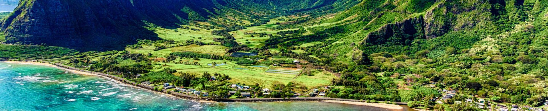 The beautiful and unique landscape of coastal Oahu, Hawaii and the Kualoa Ranch where Jurassic Park was filmed as shot from an altitude of about 1000 feet over the Pacific Ocean.